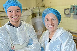 Two factory workers posing in front vats