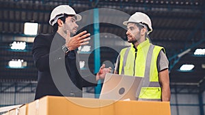 Two factory workers working and discussing manufacturing plan in the factory .