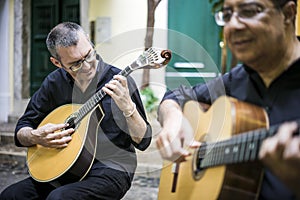 Two fado guitarists with acoustic and portuguese guitars photo