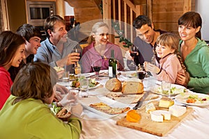 Two Familes Enjoying Meal In Alpine Chalet