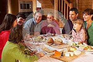 Two Familes Enjoying Meal In Alpine Chalet