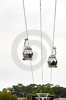 Two families enjoying aerial views inside two gondolas of the Vilanova de Gaia cable car suspended on the hanging steel cables photo