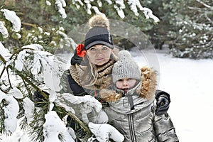 Two families walk in a winter snowy forest.