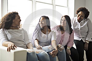 Two family Friends Sitting On Sofa Together