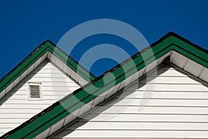 Two farmhouse roof peaks against a blue sky