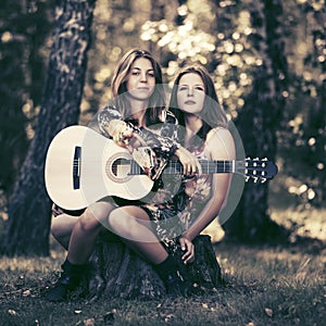 Dvě móda dívky kytara v les 