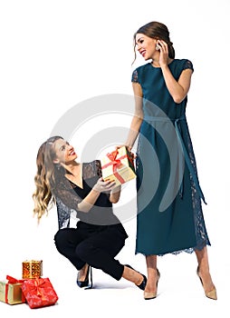 Two fashon models girl in formal party clothes with christmas presents