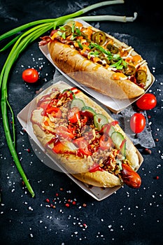 Fast food hotdog with beef sausage and fresh grilled vegetables with wheat bun on wooden background