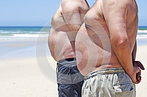 Two fat men on the beach