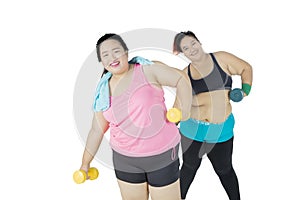 Two fat women exercising with dumbbells