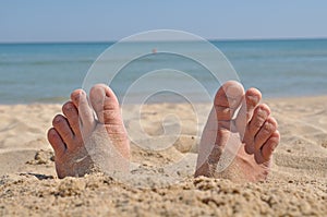 Two feet buried in sand