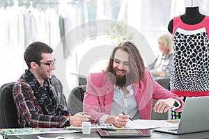 Two fellow designers sitting at a Desk in the Studio