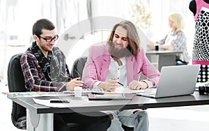 Two fellow designers sitting at a Desk in the Studio