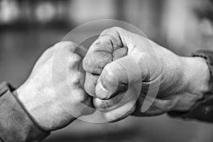 Two fellow workers greeting each other with a handshake using their fists as a symbol of companionship, friendship and solidarity