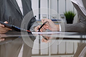 Two female accountants checking financial statement or counting by calculator income for tax form, hands close-up