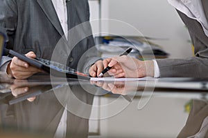 Two female accountants checking financial statement or counting by calculator income for tax form, hands close-up