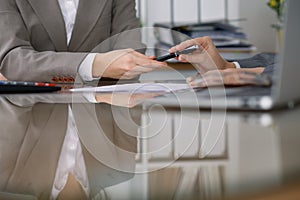 Two female accountants checking financial statement or counting by calculator income for tax form, hands close-up