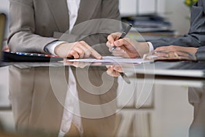 Two female accountants checking financial statement or counting by calculator income for tax form, hands close-up