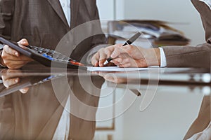 Two female accountants checking financial statement or counting by calculator income for tax form, hands close-up