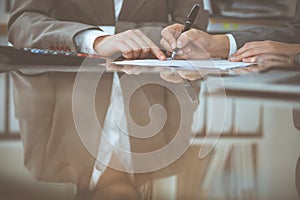 Two female accountants checking financial statement or counting by calculator income for tax form, hands close-up