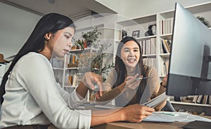 Two female accountants have a team meeting to summarize financial information in the office