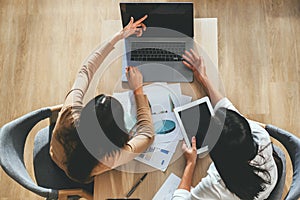 Two female accountants have a team meeting to summarize financial information in the office