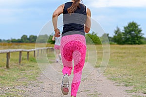 Two female adult jogger running away from camera