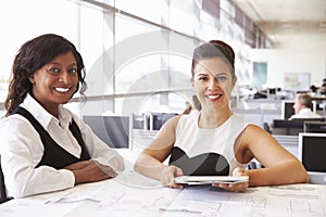 Two female architects working together, looking to camera