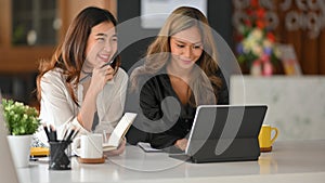 Two female business entreprenuer using tablet at a boardroom
