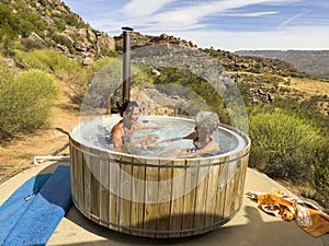 Two female campers enjoying a sit in a wood fired hot tub