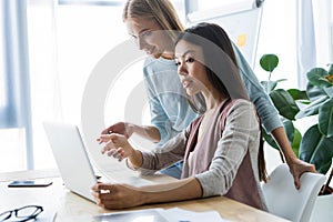 Two female colleagues in office working together.