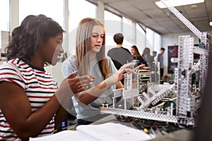 Two Female College Students Building Machine In Science Robotics Or Engineering Class photo