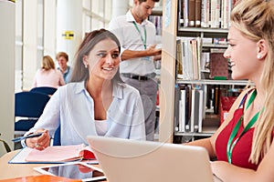 Two Female College Students Studying In Library Together