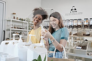 Two female customers enjoy shopping with organic products at a refill store
