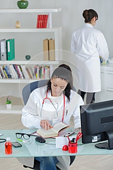 Two female doctors coleagues in office photo