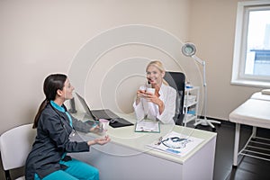 Two female doctors having a conversation after shift in clinic