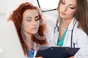 Two female doctors looking at patient information form