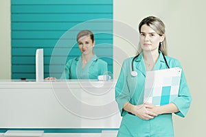 Two female doctors or nurses looking at the camera. Stethoscope on the neck