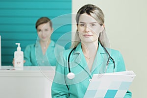 Two female doctors or nurses looking at the camera. Stethoscope on the neck