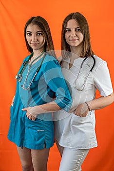 two female doctors standing back to back with crossed arms isolated on a certain background.