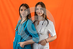 two female doctors standing back to back with crossed arms isolated on a certain background.