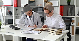 Two female doctors talking in light workplace.