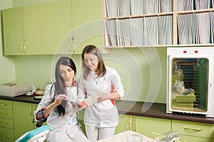 Two female doctors in white uniform at clinic office. Dentistry