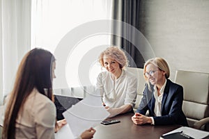 Two female experts check knowledge of woman trainee at the end of trial period