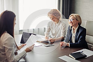 Two female experts check knowledge of woman trainee at the end of trial period