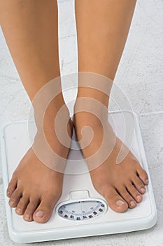 Two female feet on a bathroom scale