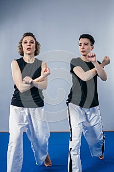Two female fighter of martial arts practice in gym. Taekwondo coach and student in personal training. Self-defense class for women