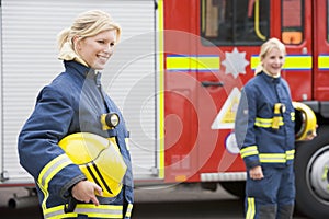 Two female firefighters by a fire engine