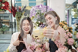 Two female florists demonstrate flower arrangements via online live streaming.
