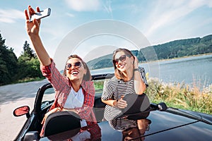 Two female freinds take a selfie photo during their auto travel